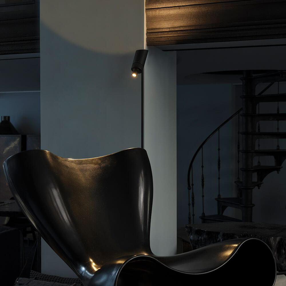 DCWéditions Vision 20/20 LED-Stehleuchte 137cm neben einem schwarzen Sessel in modernem Raum.