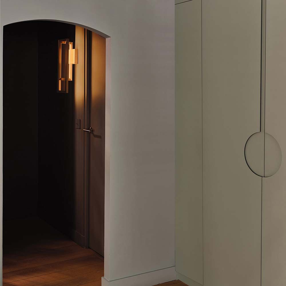 Borely LED Wandleuchte von DCWéditions, entworfen von Eric Gizard, strahlt warmes Licht in einem modernen Raum.
