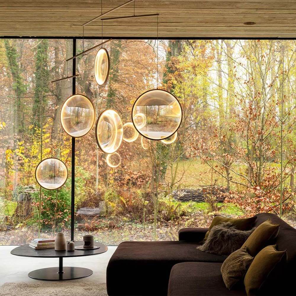DCWéditions Focus LED Hängeleuchte 5-flammig in einem modernen Wohnraum mit Aussicht auf die Natur.