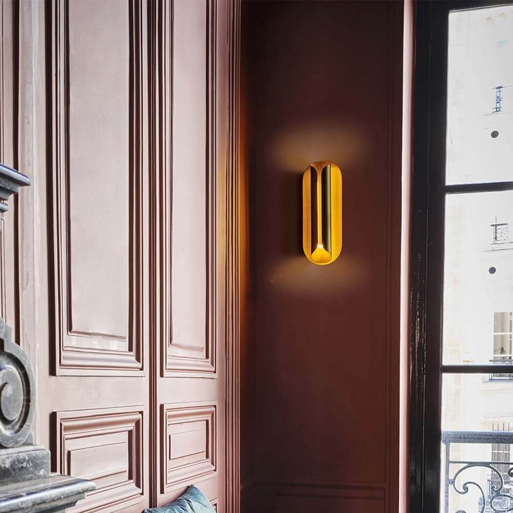 DCWéditions Rosalie LED Wandleuchte Blattgold an einer Wand, die warmes Licht ausstrahlt.