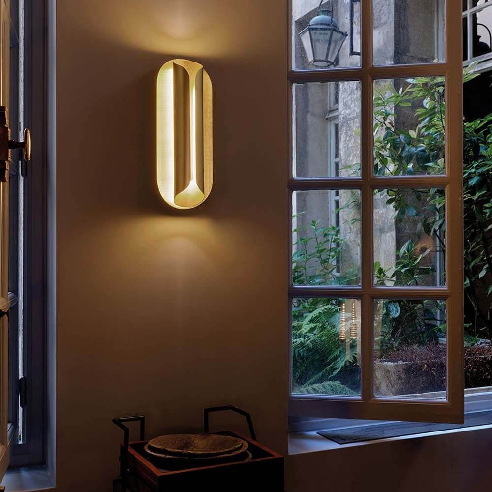 DCWéditions Rosalie LED Wandleuchte Blattgold an einer Wand mit warmem Licht und elegantem Design.