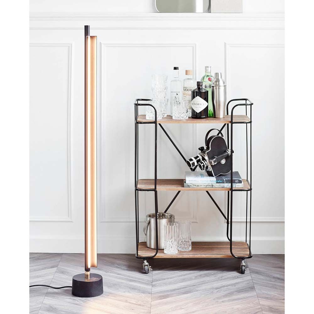 LED Stehlampe SpaceB in Schwarz und Opal Weiß neben einem eleganten, minimalistischen Regal.