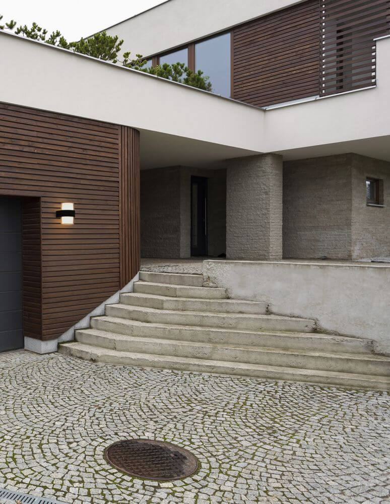 Darf LED Außenwandleuchte Up & Down 3000K Schwarz IP54 an moderner Hausfassade mit Treppen und Steinen.