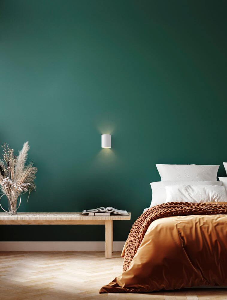 Dazle Wandleuchte Ø 8cm an einer grünen Wand in einem modern gestalteten Schlafzimmer.