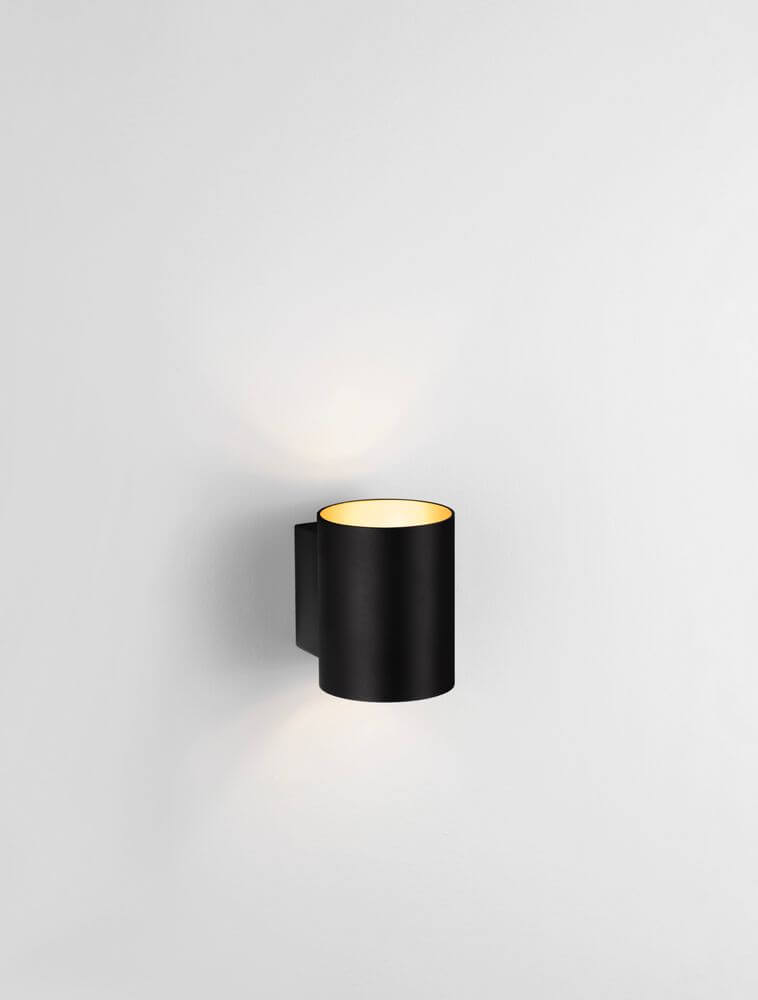 Dazle Wandleuchte Ø 8cm an der Wand, stilvolles Design in Schwarz und Gold.