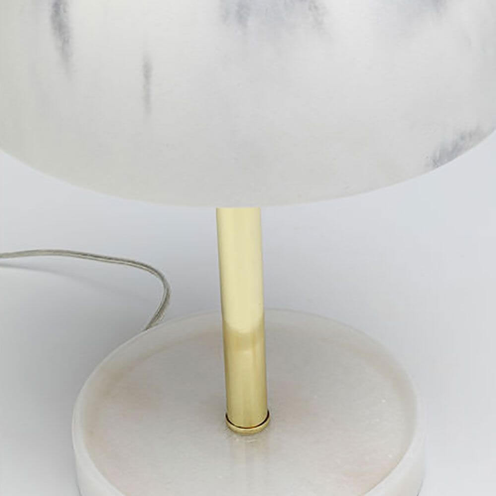 Detailansicht der Design Tischleuchte Horn mit marmoriertem Lampenschirm und goldenem Fuß.