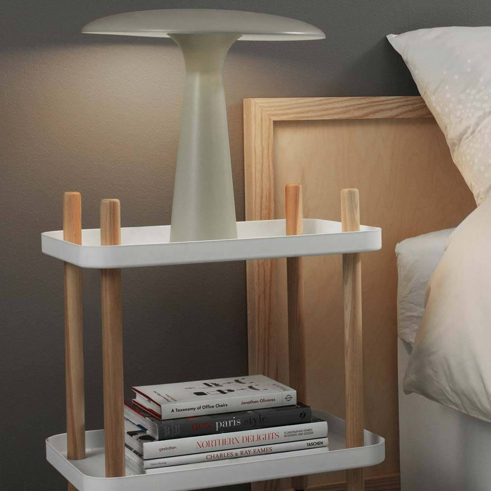 Design Tischleuchte Shelter aus Kalkstein mit modernem, freundlichem Lampenschirm auf einem Nachttisch.