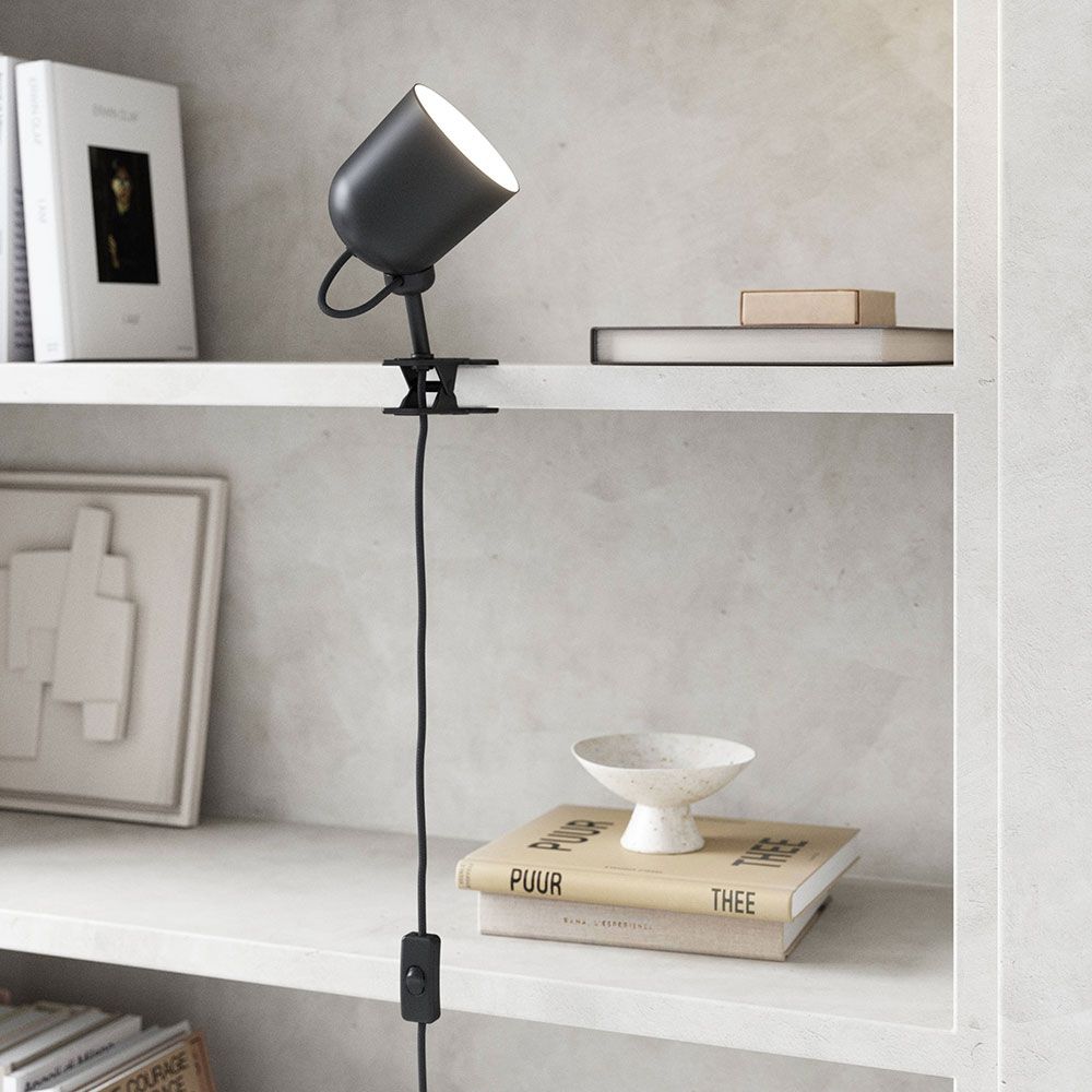 Moderne Angle Klemmleuchte von Maria Berntsen, flexibel einstellbar auf einem Regal.