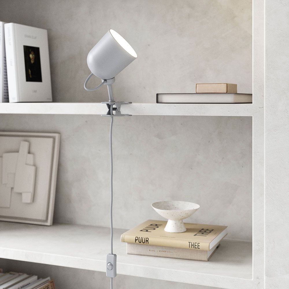 Moderne Angle Klemmleuchte von Maria Berntsen auf einem Regal, perfekt für gerichtetes oder indirektes Licht.