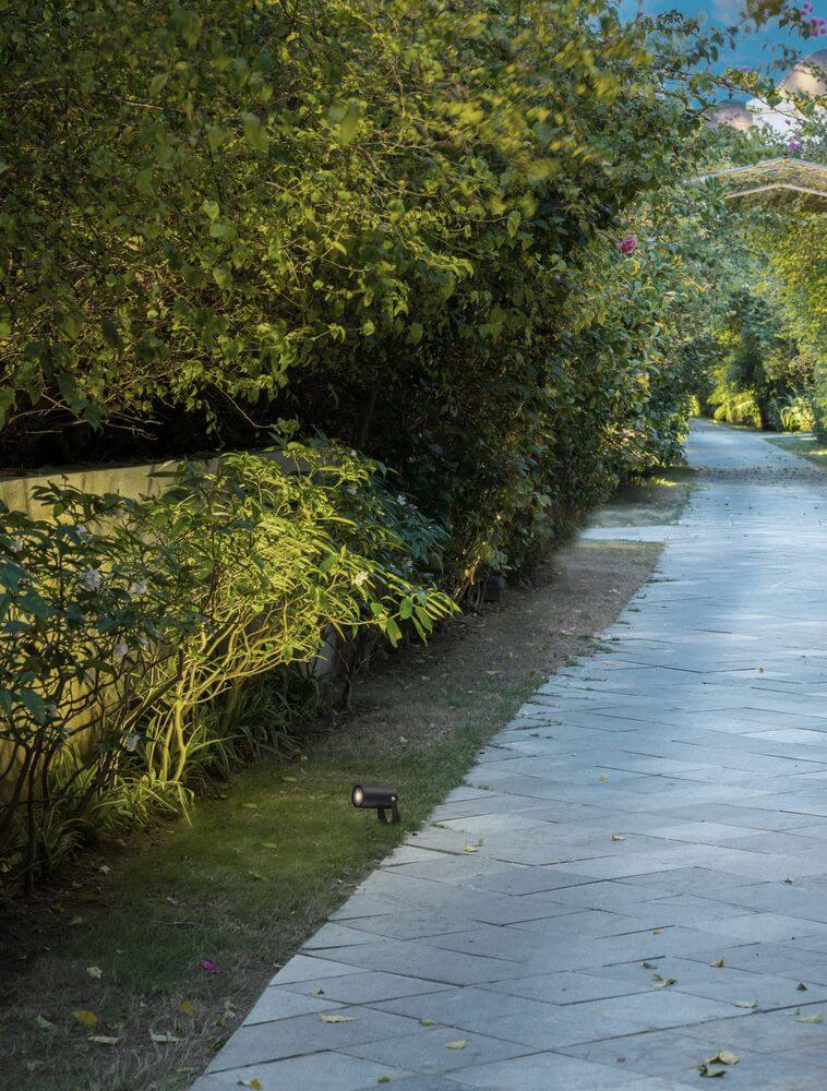 Destry Außenwandleuchte Schwarz IP54 beleuchtet einen Gartenweg mit modernem Licht.