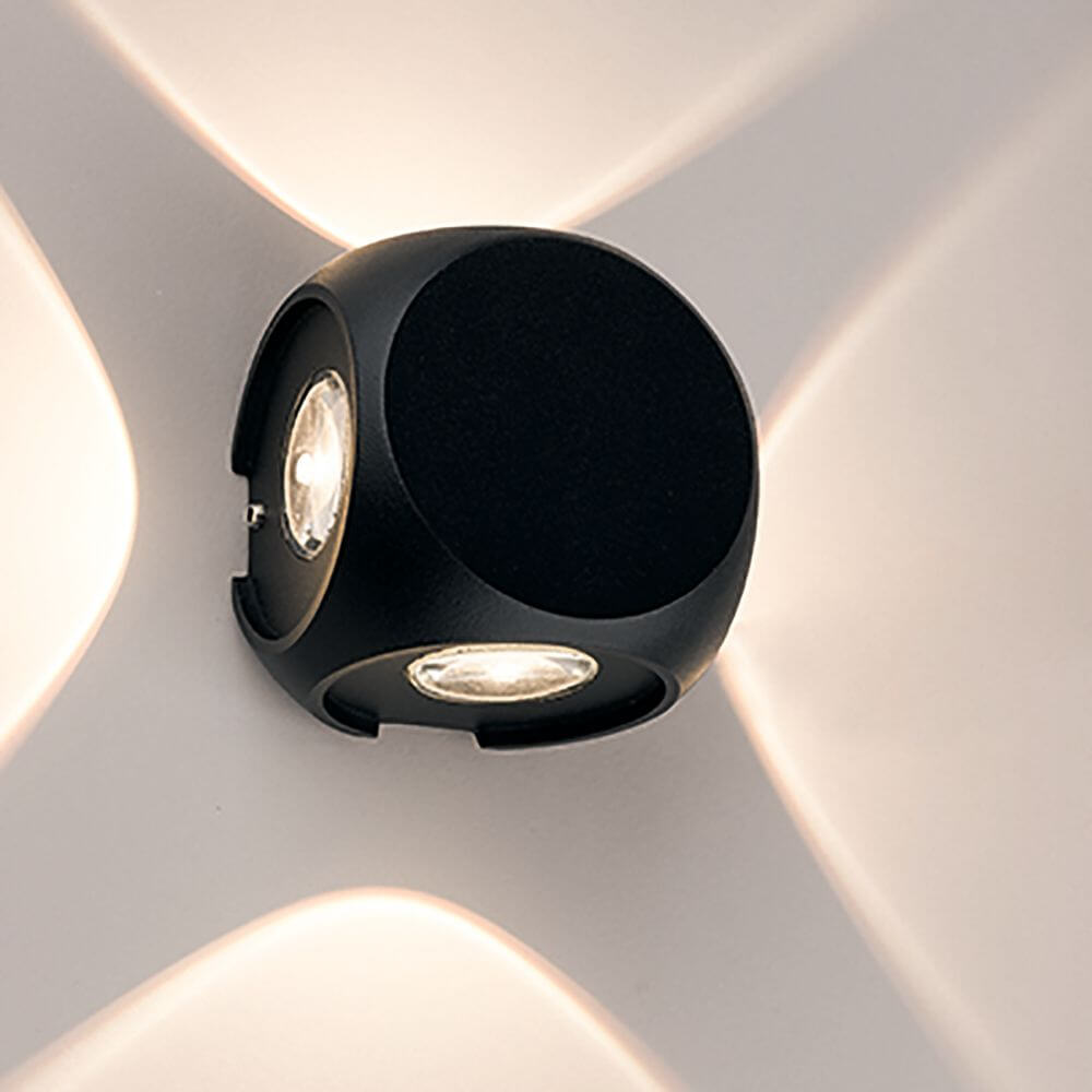 Patras LED Außen-Wandleuchte 4-flammig Schwarz IP54 an Wand montiert, minimalistisches Design, strahlt Licht in vier Richtungen.