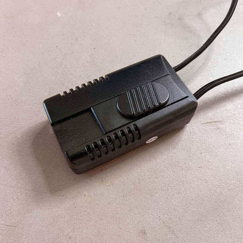 Musta sähköinen kytkin kiiltävällä pinnalla harmaalla taustalla, ihanteellinen erilaisiin sähköprojekteihin.