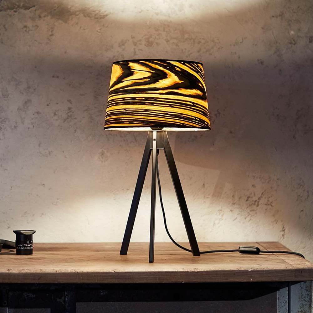 Dreibeintischlampe Attica 60cm White Ebony auf einem Holztisch mit stylischem Design und dekorativem Lampenschirm.