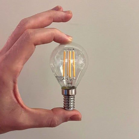 s.luce E14 LED Ciepła biel 2700K 350lm 4W Ściemniacz CRI 90 trzymany w ręce, przezroczysta konstrukcja szklana.