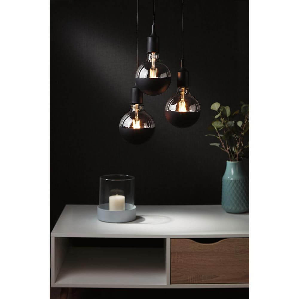 E27 6,5W LED Globe Kopfspiegel 2700K Schwarz-Matt Dimmbar mit drei hängenden Lampen und blühender Dekoration.