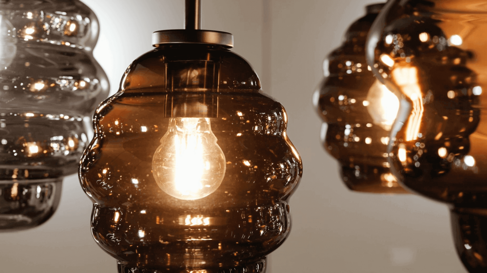 Große, moderne Glaskuppelleuchten mit warmem Lichtschein im Hintergrund.