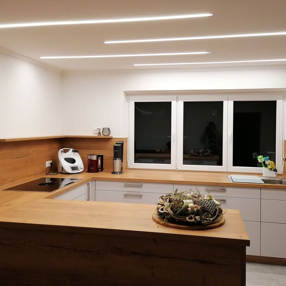 Einbauprofil tief 200cm Alu-eloxiert ohne Abdeckung für LED-Strips in moderner Küche mit Holzdekor.