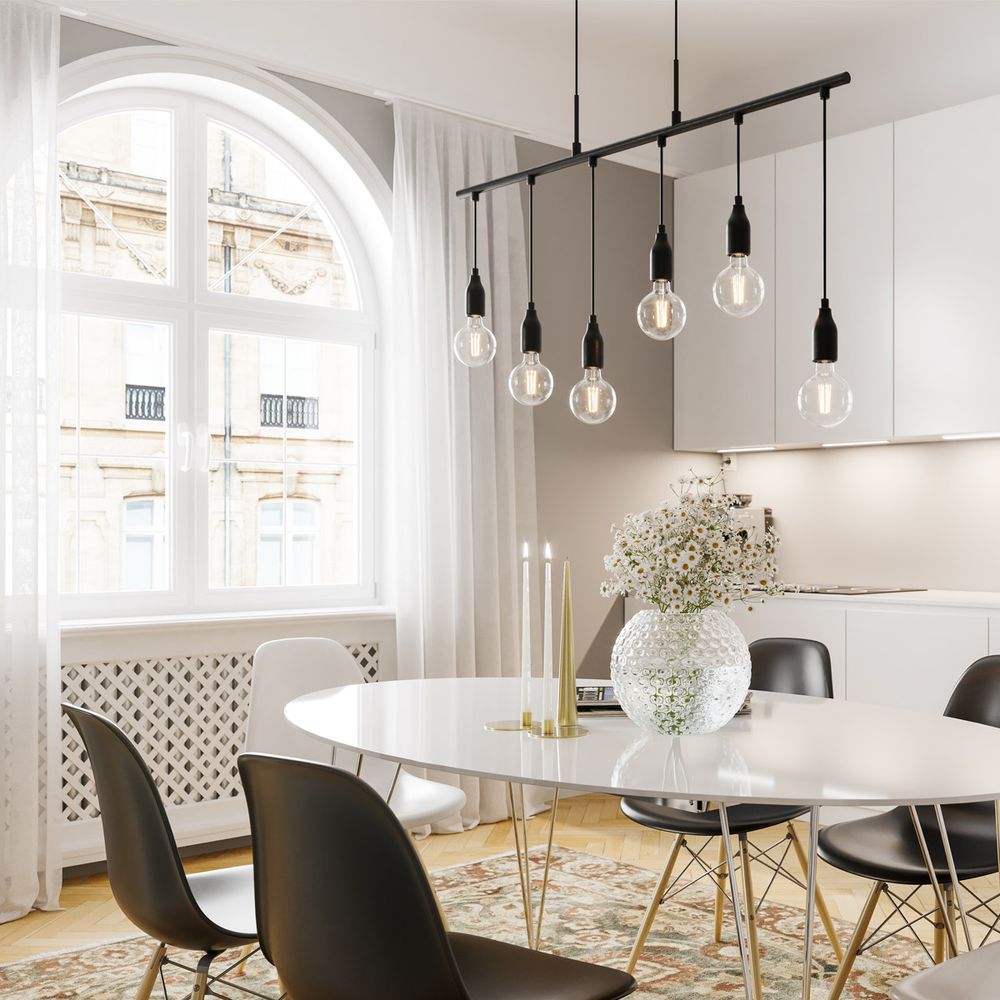 Hängeleuchte Skyline Schwarz mit sechs Kabeln über einem modernen Esstisch im hellen Raum.