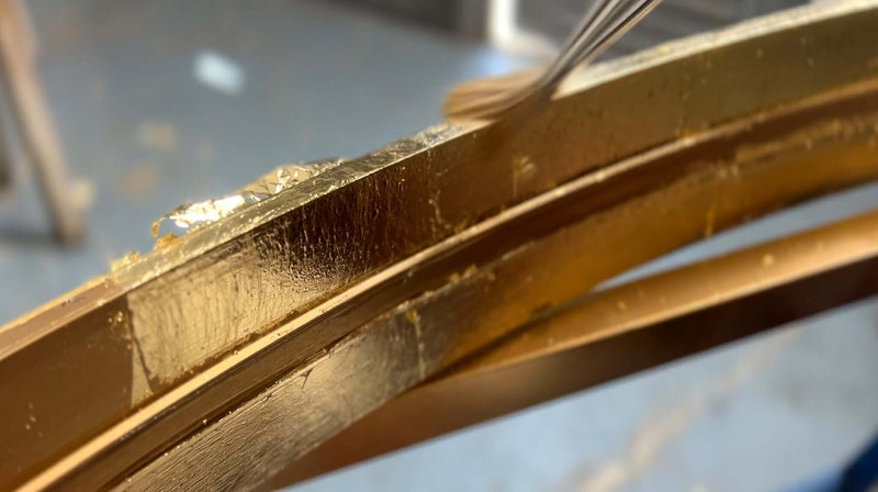 Nahaufnahme von goldverziertem Rahmen mit künstlerischer Oberflächenbearbeitung.