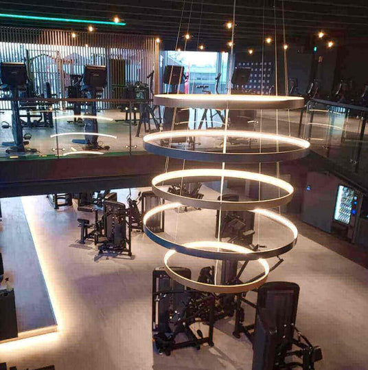 Modernes Fitnessstudio mit stilvollem Ringlicht und funktionalen Trainingsgeräten.