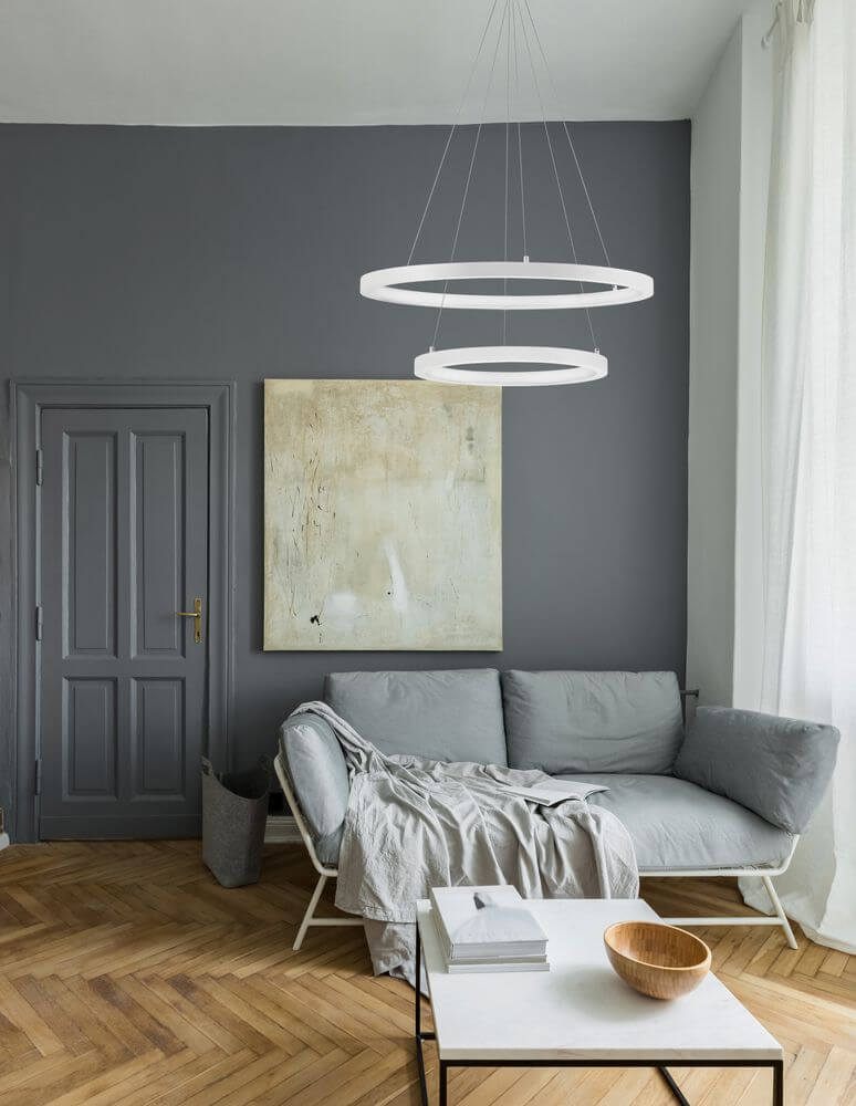 Empatia LED Pendelleuchte 2-flammig Ø 60cm 3000K im modernen Wohnraum mit grauen Wänden und hellem Sofa.