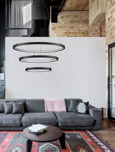 Empatia LED Pendelleuchte 3-flammig Ø 80cm 3000K über modernem Sofa im Wohnraum