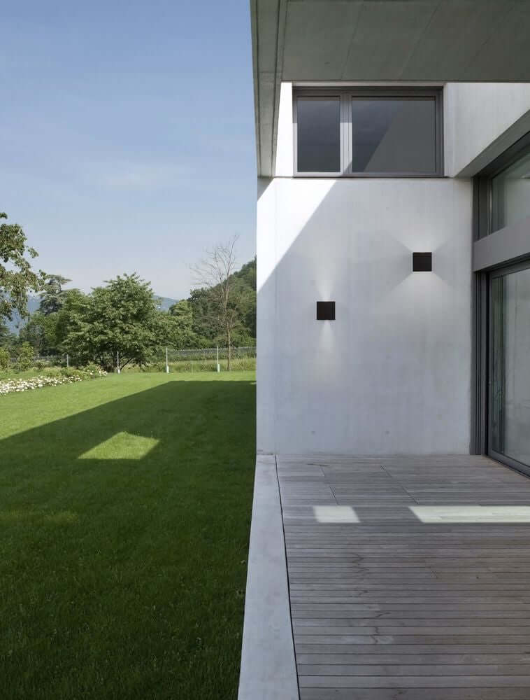 Epic LED Außenwandleuchte Cube 3000K IP54 an moderner Hauswand mit Gartenanlage im Hintergrund