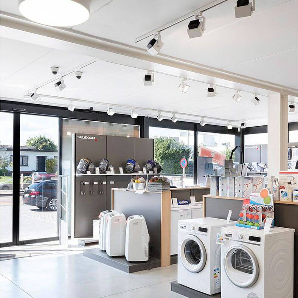 Moderne Verkaufsumgebung mit Euro Cube LED Strahlern und Haushaltsgeräten in einem Geschäft.