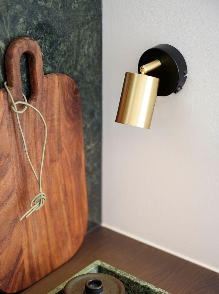 Explore Wand Spot Messing an einer Wand mit modernem Kücheninterieur und Holzbrett.