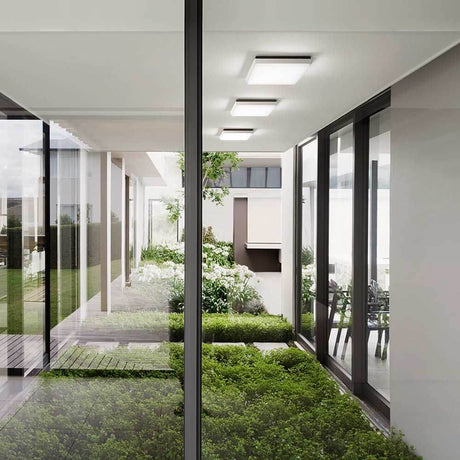 Desdy moderne LED Deckenleuchte in modernem Raum mit Sicht auf Garten und Pflanzen.