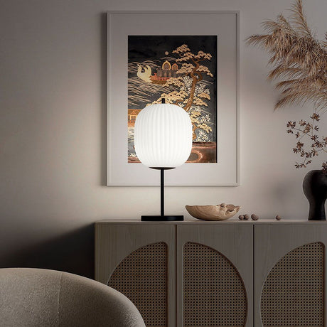 Domizia Glas-Tischlampe Weiß, Schwarz auf einem Sideboard in modernem Interieur.