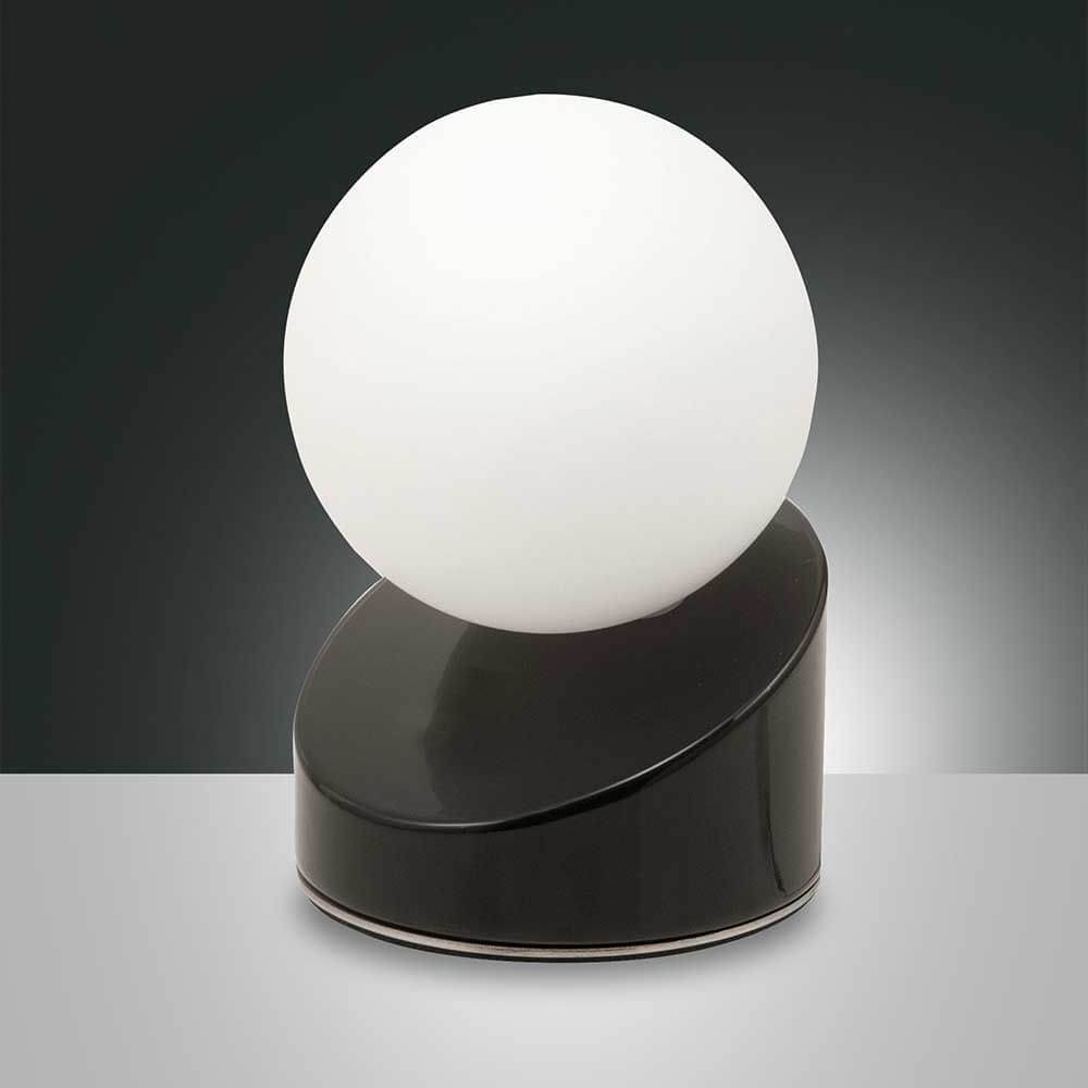 Gravity LED Tischleuchte aus Metall & Glas mit runder, mattweißer Glaskugel und schwarzem Sockel.