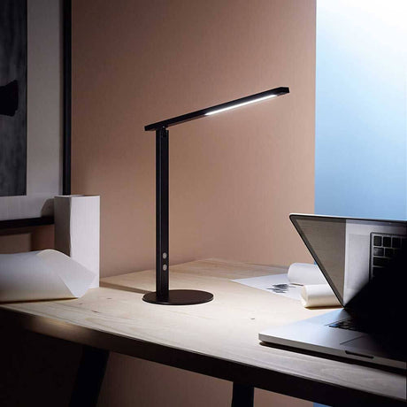 Ideal LED Tischlampe auf einem Tisch neben einem Laptop, ideal für modernes Arbeiten.