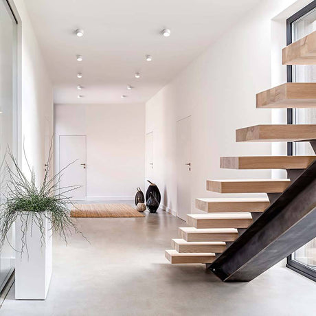 LED Deckenleuchte Vasto 630lm Weiß in modernem Eingangsbereich mit Treppe und Pflanzen.