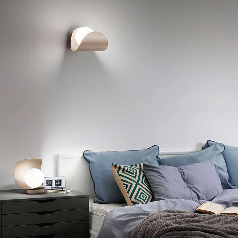 LED Tischlampe Adria aus Metall auf Nachttisch neben Bett und dekorativen Kissen.