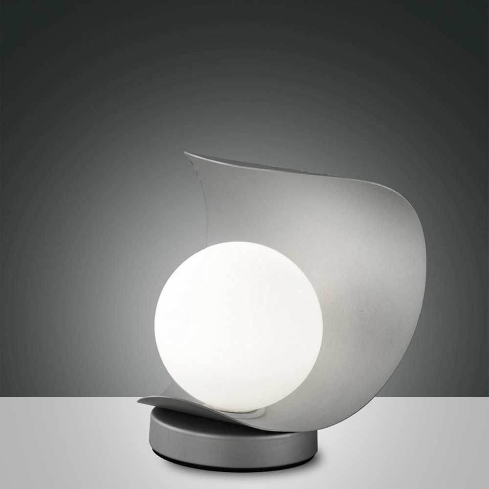 LED Tischlampe Adria aus Metall auf einem modernen Tisch, elegantes Design mit runder Leuchte.