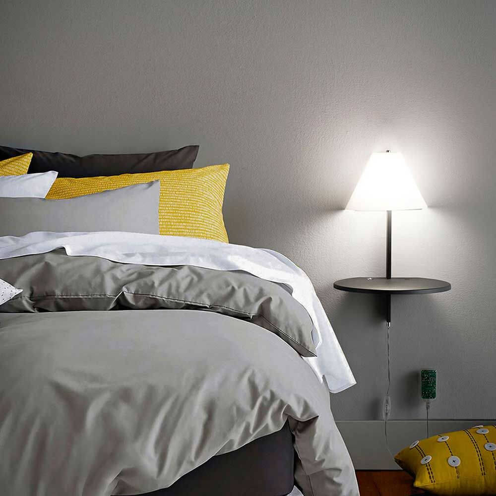 LED Wandlampe Goodnight Metall an einer Wand neben einem Bett mit gemütlicher Bettwäsche.