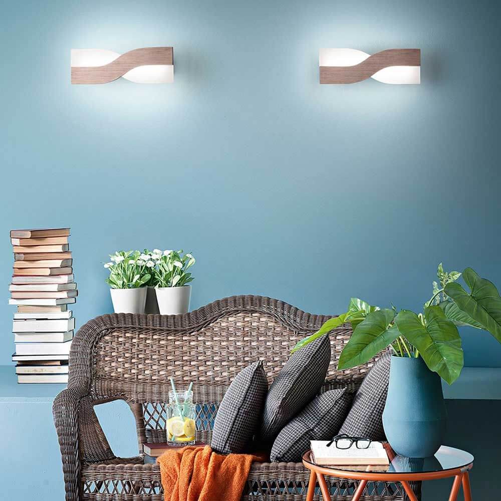 LED Wandlampe Riace Metall in modernem Raum mit bequemen Möbeln und Pflanzen.
