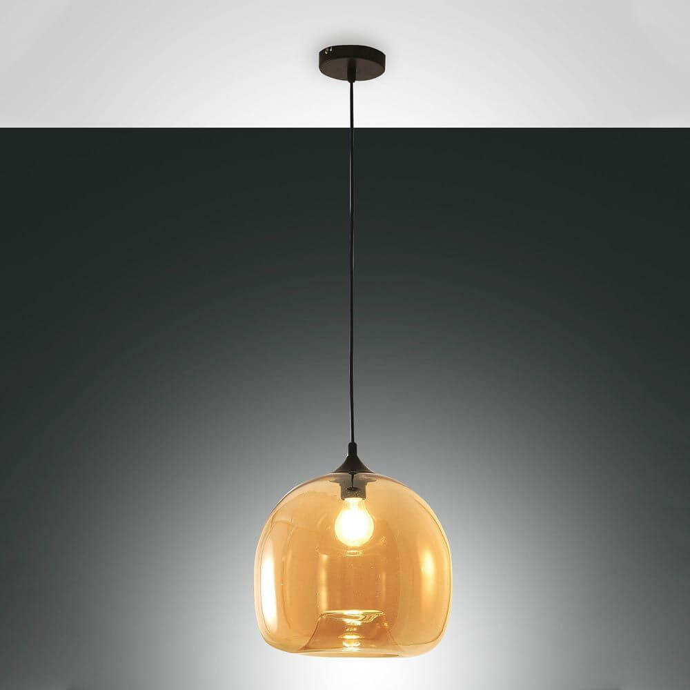 Maia formschöne Glas-Pendelleuchte in Amber hängt elegant über einem Esstisch.