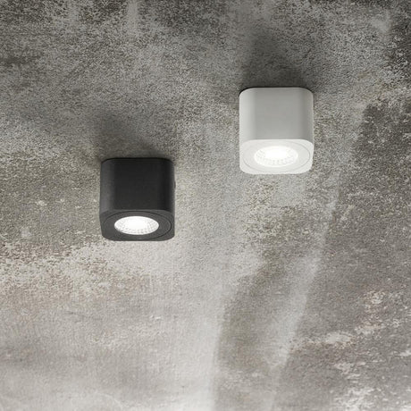 Palmi Spot Anthrazit und Weiß an einer Wand montiert, minimalistische Form, moderne LED-Technologie.