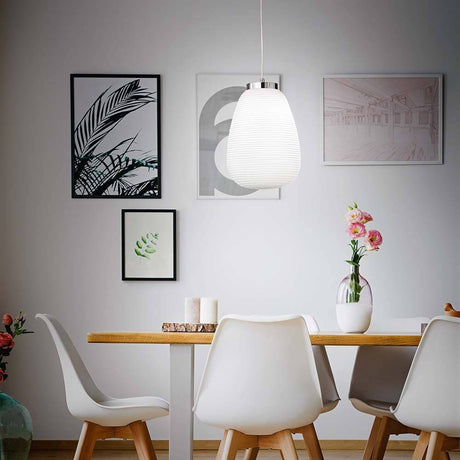 Cora White pendant lamp hanging above a modern dining table in a stylish room.