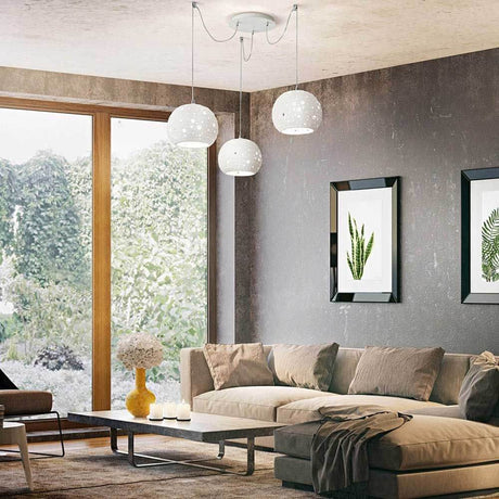 Pendellampe Corvara Ø 25cm in modernem Wohnzimmer mit Pflanzenbildern und bequemer Couch.