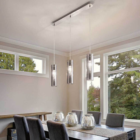 Pendelleuchte Sintesi 3-flammig über einem modernen Esszimmer Tisch mit fünf Stühlen.