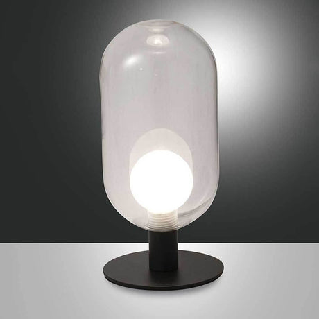 Tischleuchte Gubbio Ø 10cm auf schwarzem Untergrund mit glasklarer Kuppel und heller LED-Birne.