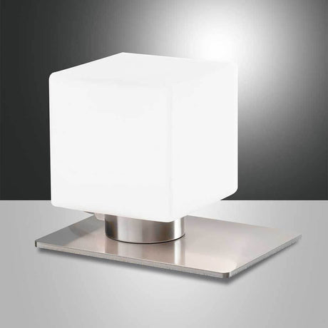 Tischlicht Zara 3000K auf einem modernen Metallständer mit kubischer, weißer Glasabdeckung.