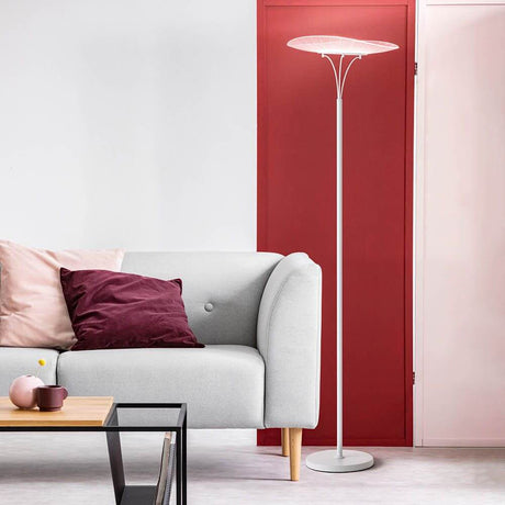 Vela LED Stehleuchte aus Metall neben einem modernen grauen Sofa in einem stilvollen Raum.