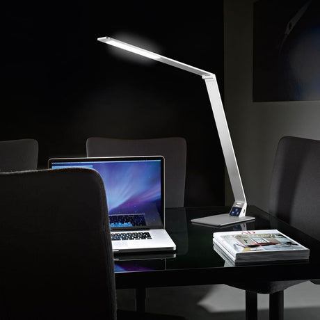 Moderne Wasp Tischleuchte aus Aluminium mit USB-Anschluss auf einem Schreibtisch neben einem Laptop.