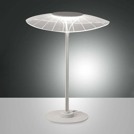 moderne LED Tischlampe Vela Weiß auf einem Tisch mit modernem Design und leuchtendem Licht.