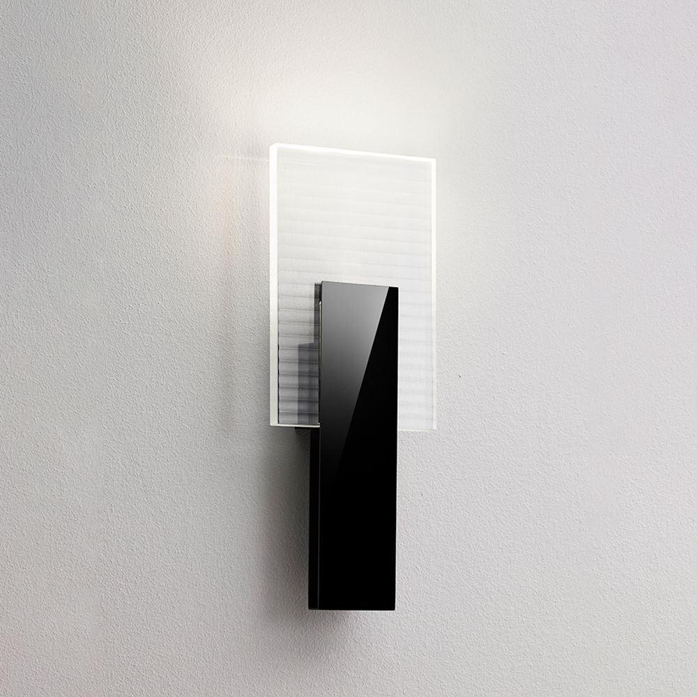 Fabbian Amulette LED-Wandlampe mit geripptem Glasdiffusor und schwarzem Metallrahmen.
