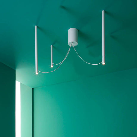 Fabbian Ari LED 3-light pendant light in a modern design and white finish on a green background.
